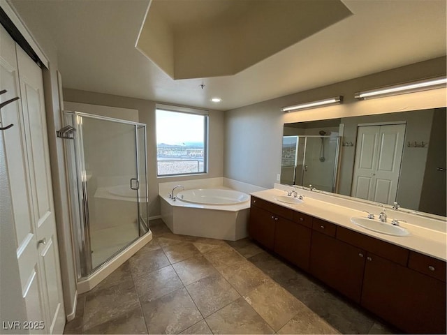 full bath with a garden tub, double vanity, a stall shower, and a sink