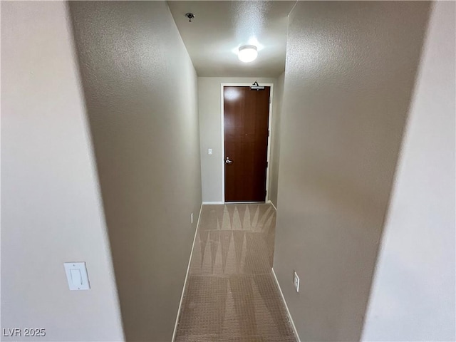 hall featuring carpet and baseboards