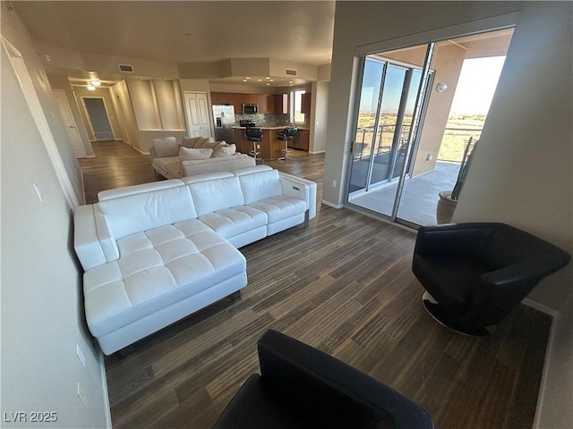 living area featuring dark wood-type flooring and visible vents