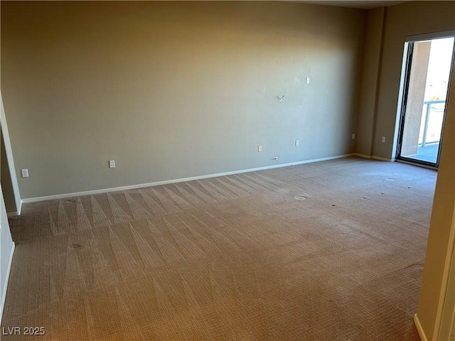 unfurnished room with light colored carpet and baseboards