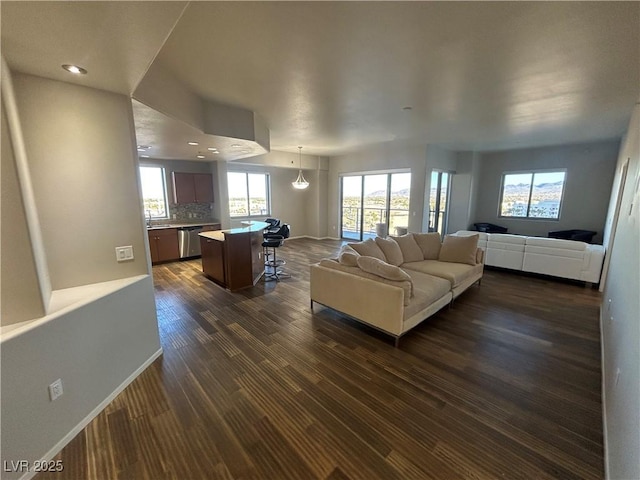 living area with dark wood-style flooring, recessed lighting, and baseboards