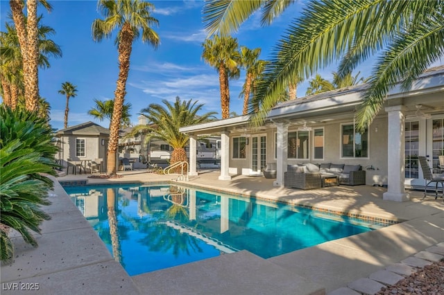 view of pool with a patio area, outdoor lounge area, french doors, and ceiling fan