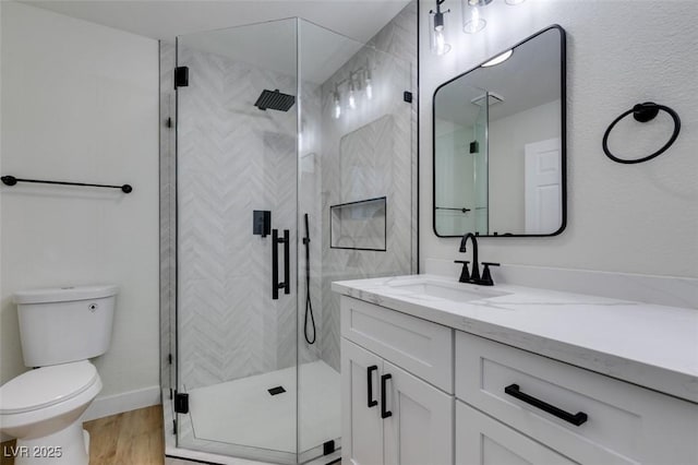 bathroom with vanity, hardwood / wood-style floors, toilet, and walk in shower