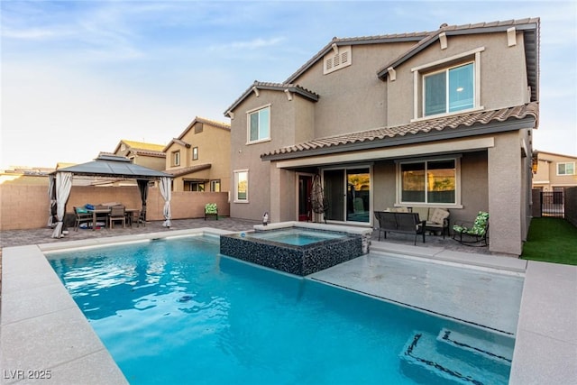 view of pool with a patio area, an in ground hot tub, and a gazebo