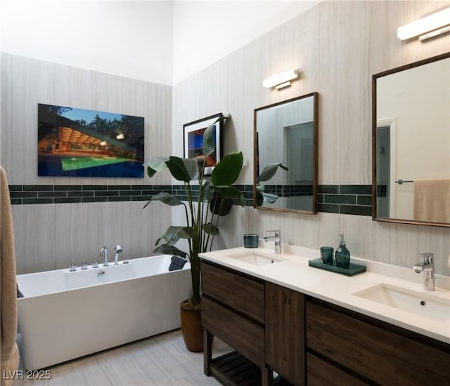 full bathroom featuring a sink, a freestanding bath, and double vanity