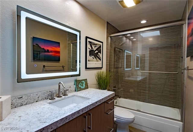 full bath with toilet, shower / bath combination with glass door, and vanity