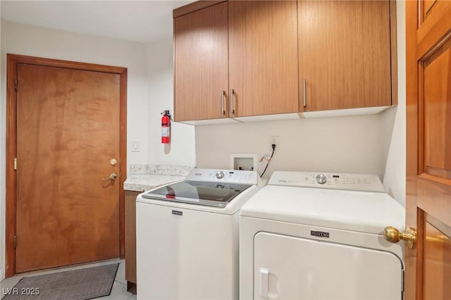 laundry area featuring washer and clothes dryer and cabinet space