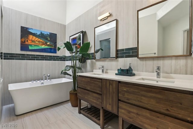 full bathroom featuring a freestanding tub, a sink, and double vanity