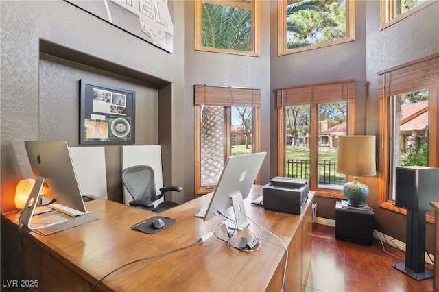 home office with a towering ceiling and baseboards