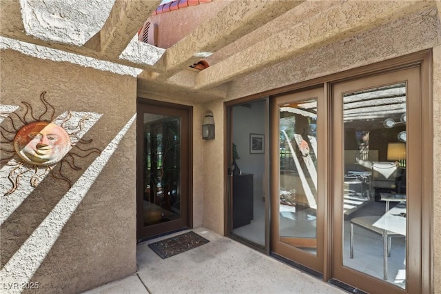 view of exterior entry with stucco siding