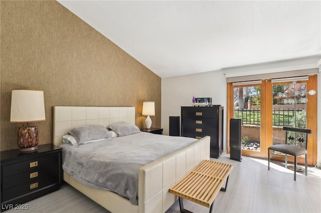 bedroom featuring lofted ceiling and access to outside