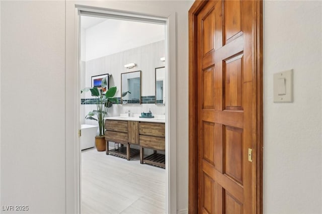 bathroom with double vanity and a freestanding tub