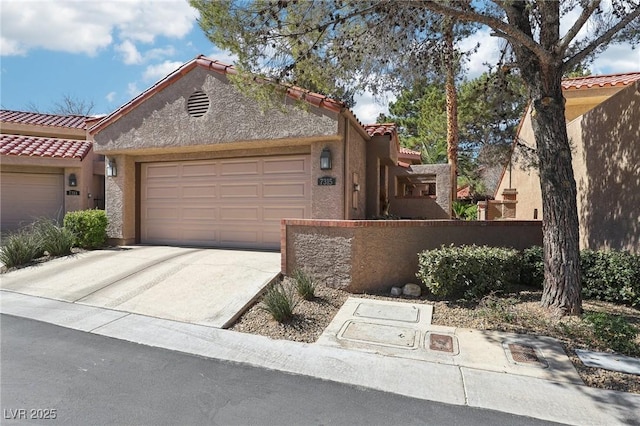 view of front of property featuring a garage, driveway, a tile roof, and stucco siding