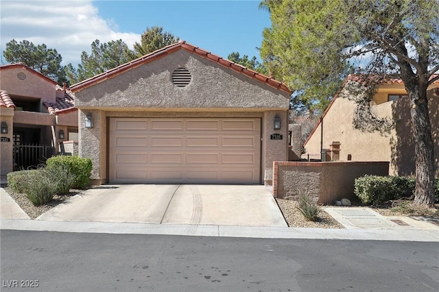 view of front of house featuring stucco siding, an attached garage, fence, driveway, and a tiled roof