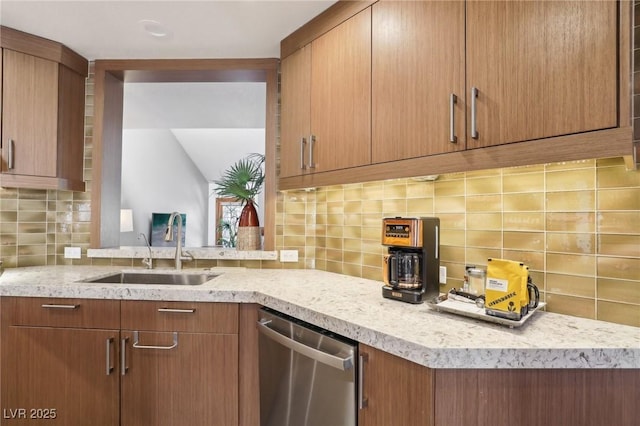 kitchen featuring light stone counters, brown cabinets, backsplash, stainless steel dishwasher, and a sink