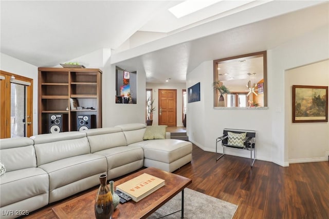 living area featuring vaulted ceiling with skylight, baseboards, and dark wood-style flooring