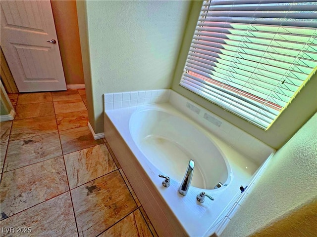 bathroom with tile patterned flooring and a relaxing tiled tub