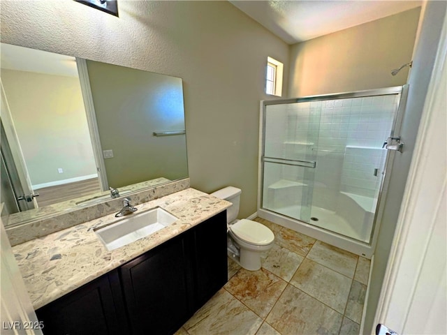 bathroom featuring vanity, an enclosed shower, and toilet