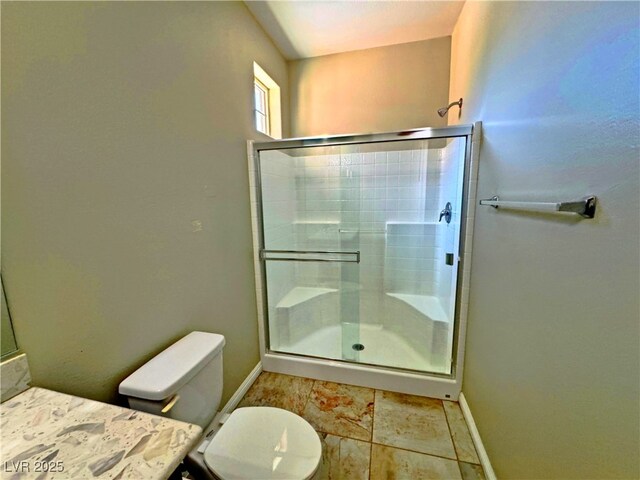 bathroom with a shower with door and toilet