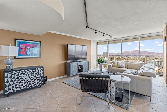 3111 Bel Air Dr Unit 20D, Las Vegas, NV 89109 - tiled living room with track lighting, a wall of windows, and a textured ceiling