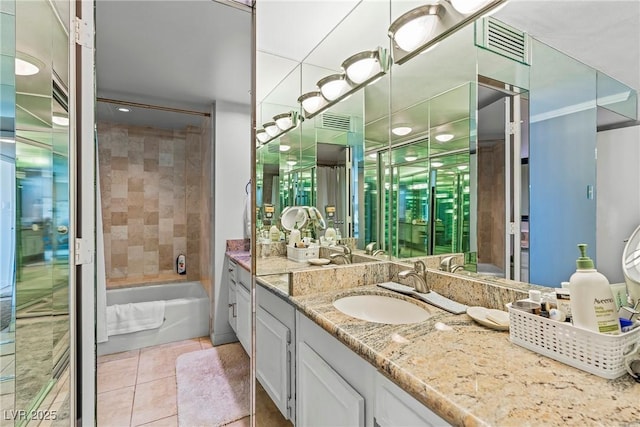 bathroom with tile patterned flooring, vanity, and tiled shower / bath combo