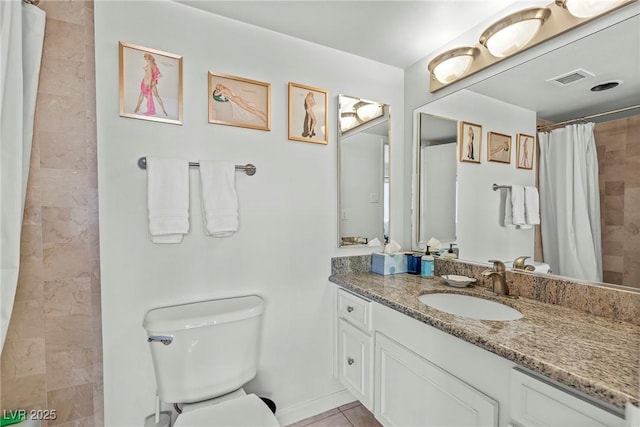bathroom featuring vanity, tile patterned flooring, toilet, and walk in shower