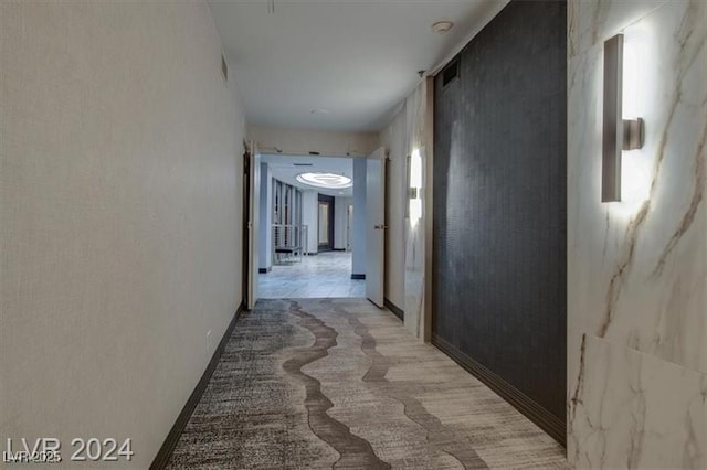 hall featuring light colored carpet