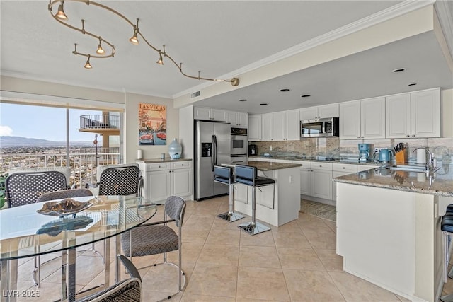 kitchen with appliances with stainless steel finishes, sink, white cabinets, ornamental molding, and light tile patterned floors