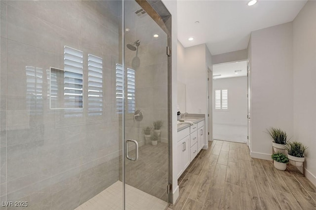 bathroom with an enclosed shower, vanity, and wood-type flooring