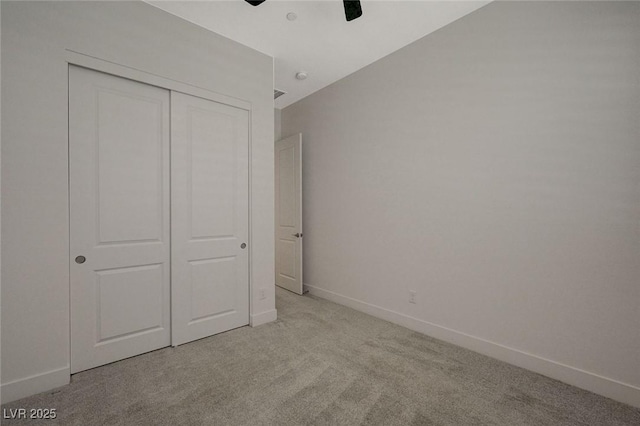 unfurnished bedroom with ceiling fan, light colored carpet, lofted ceiling, and a closet