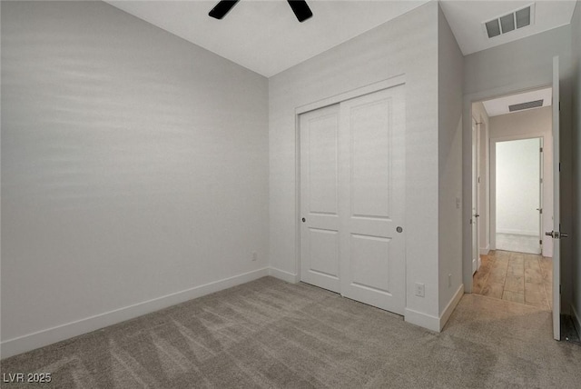 unfurnished bedroom featuring lofted ceiling, light colored carpet, a closet, and ceiling fan