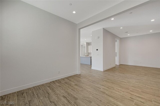 unfurnished room with sink and light hardwood / wood-style flooring