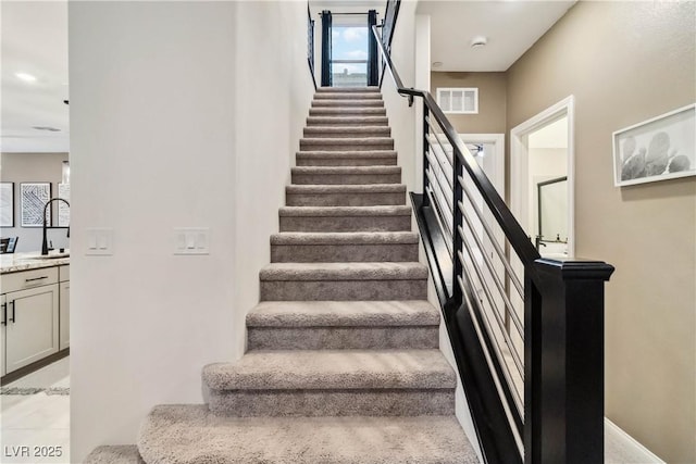 stairway featuring sink