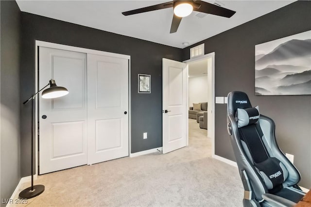 carpeted office space with ceiling fan