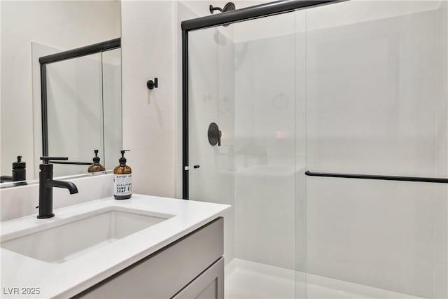 bathroom featuring a shower with door and vanity