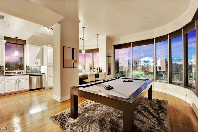 rec room with crown molding, pool table, and light hardwood / wood-style floors