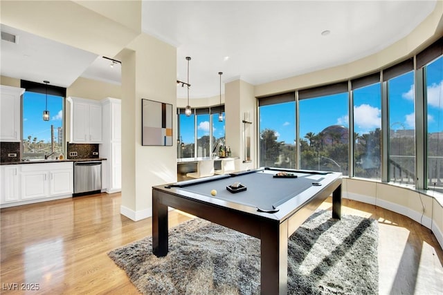 recreation room with billiards, ornamental molding, and light wood-type flooring