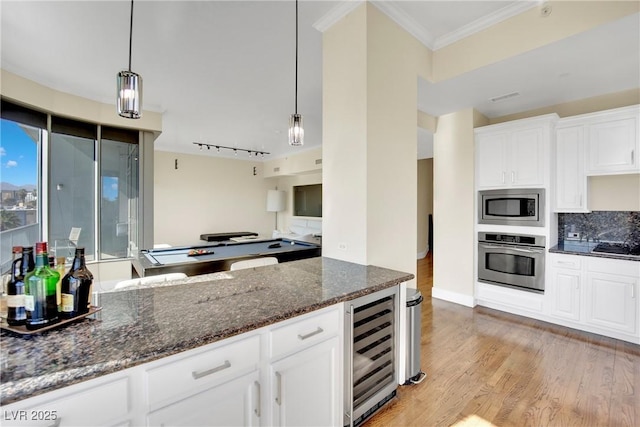 kitchen featuring stainless steel appliances, white cabinetry, pendant lighting, and wine cooler