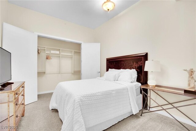 bedroom featuring a closet, light carpet, and a walk in closet