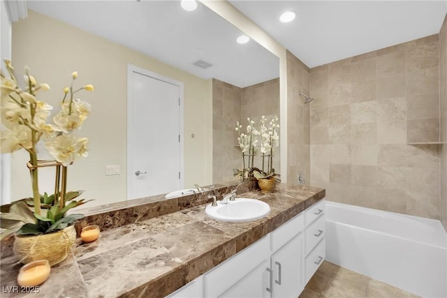 bathroom with tiled shower / bath combo, vanity, and tile patterned floors