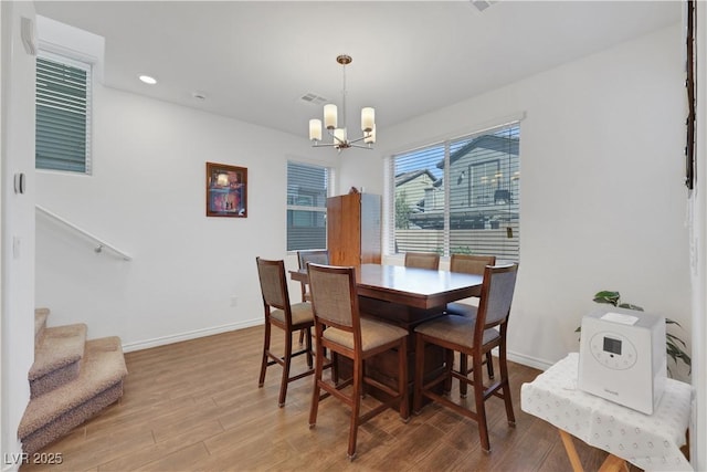 dining room with hardwood / wood-style flooring and an inviting chandelier