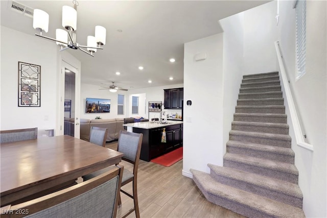 dining area featuring sink, a chandelier, and light wood-type flooring