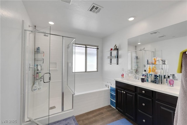 bathroom featuring vanity, independent shower and bath, and hardwood / wood-style floors