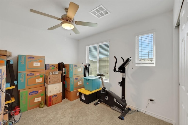 exercise room with ceiling fan and carpet