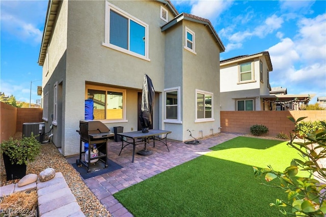 rear view of property featuring a patio, central AC unit, and a lawn