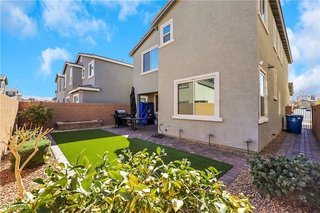 back of property with a yard and a patio area