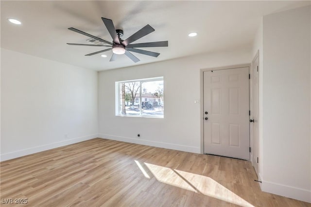 empty room with light wood-type flooring, baseboards, and recessed lighting