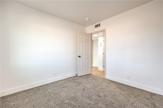 unfurnished room featuring baseboards, visible vents, and light colored carpet