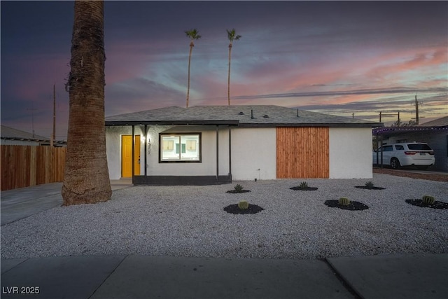 rear view of property with fence and stucco siding