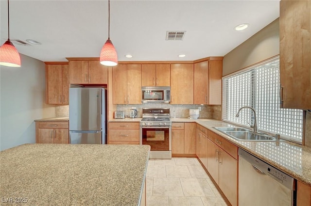 kitchen featuring sink, backsplash, stainless steel appliances, and pendant lighting